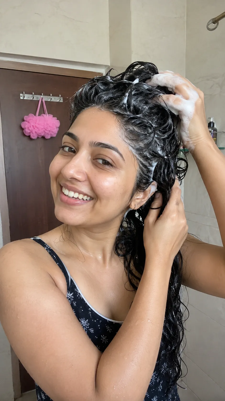 Indian woman washing hair with shampoo lather